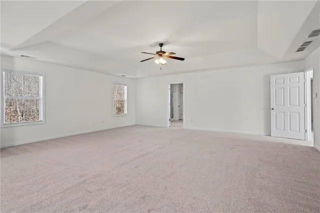 a view of a big room with chandelier fan and windows