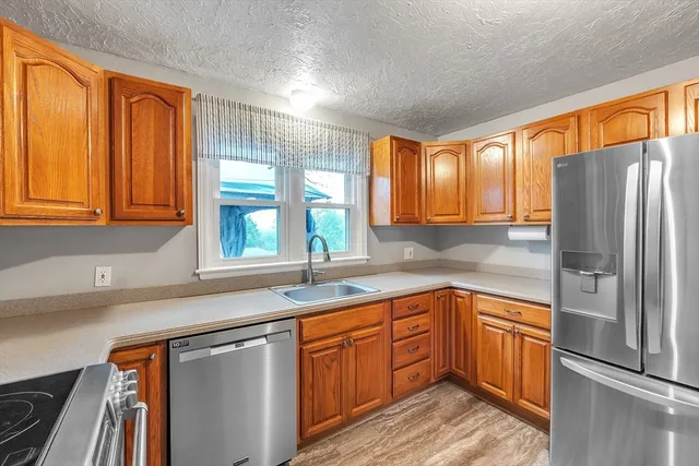 a kitchen with stainless steel appliances granite countertop a refrigerator and sink