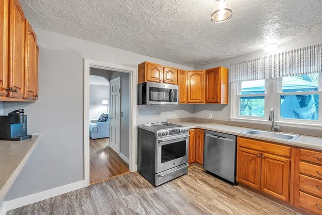 a kitchen with stainless steel appliances granite countertop a stove a sink and a refrigerator