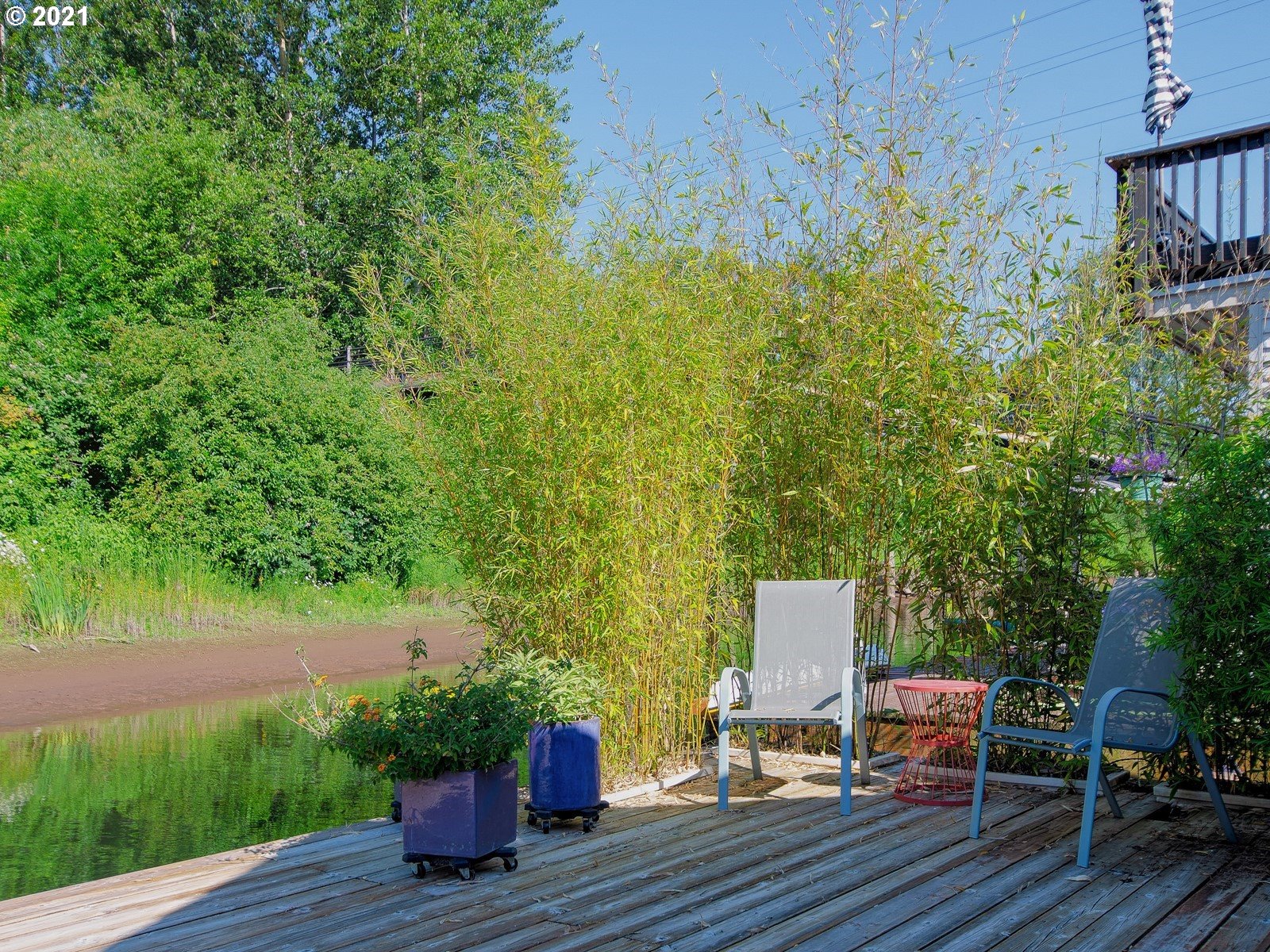 7720 South Macadam Avenue, Unit 8 Portland, OR 97219 - Photo 25 of 32 a wooden bench sitting in backside of a house with potted plants and wooden floor
