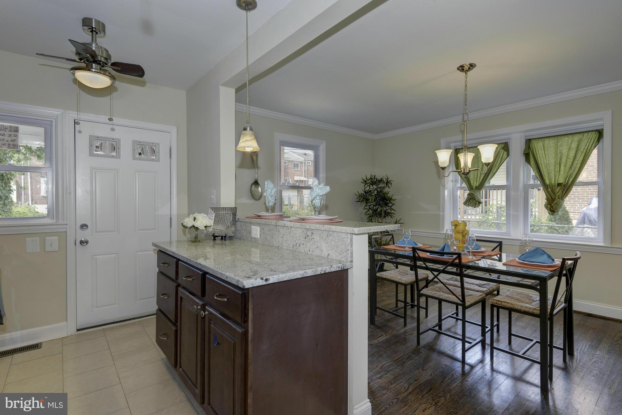 1901 Swansea Road Baltimore, MD 21239 - Photo 12 of 28 a kitchen with a table chairs a sink dishwasher window and cabinets