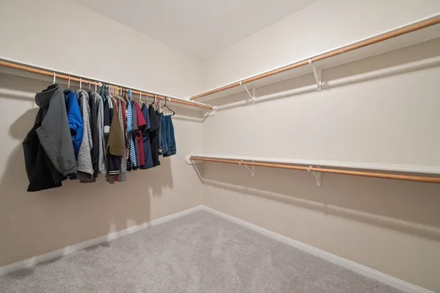 a view of walk in closet with clothes