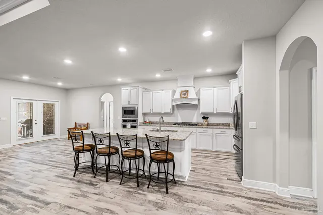 a kitchen with granite countertop a sink stainless steel appliances and cabinets