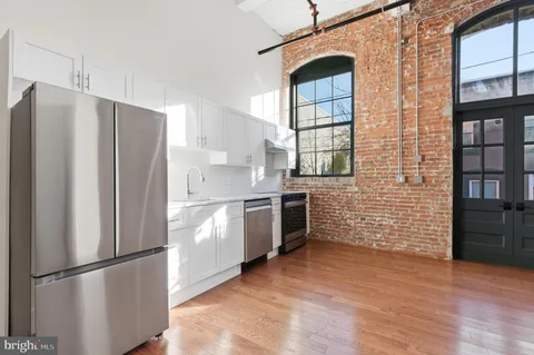 a kitchen with stainless steel appliances a refrigerator and a stove top oven