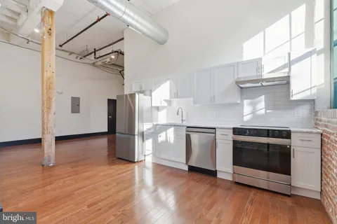 a kitchen with a stove a refrigerator and a fireplace