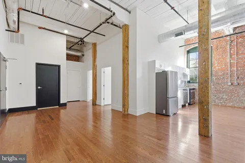 a view of a big room with wooden floor and windows