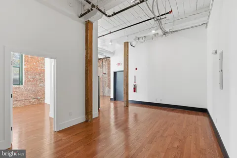 a view of a big room with wooden floor and windows