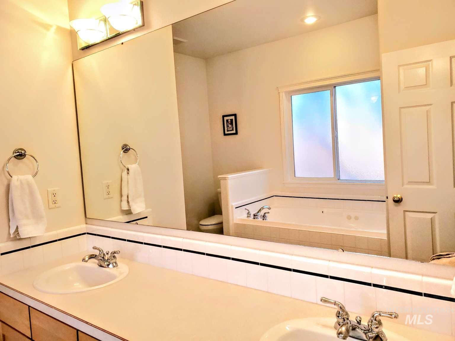 1100 East Wright Street Boise, ID 83706 - Photo 17 of 25 Dual vanity with integrated sinks, chrome faucets, and a light-toned countertop