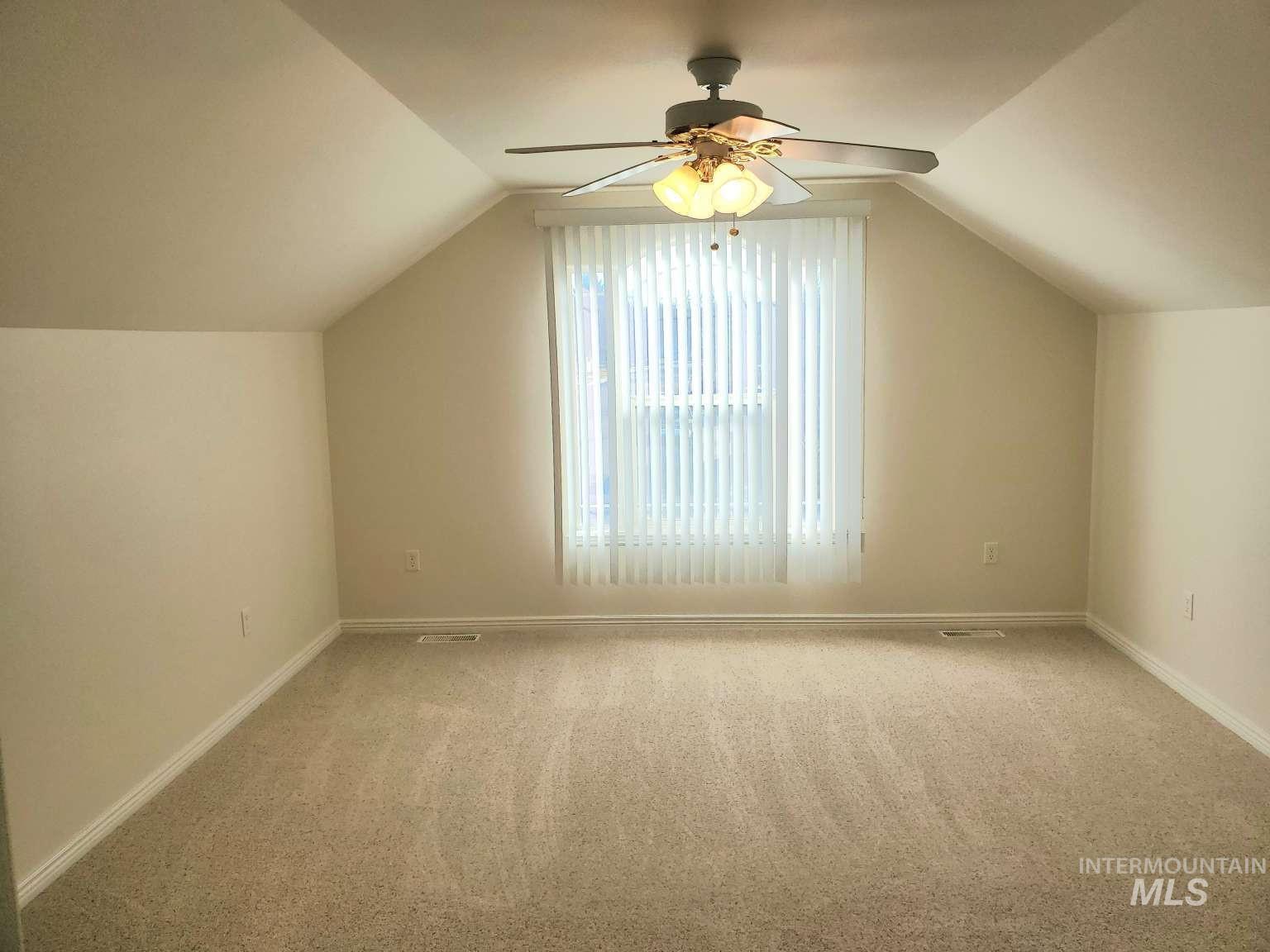 1100 East Wright Street Boise, ID 83706 - Photo 19 of 25 Carpeted room featuring a sloped ceiling, a window with vertical blinds, a ceiling fan with integrated lighting, and neutral wall tones