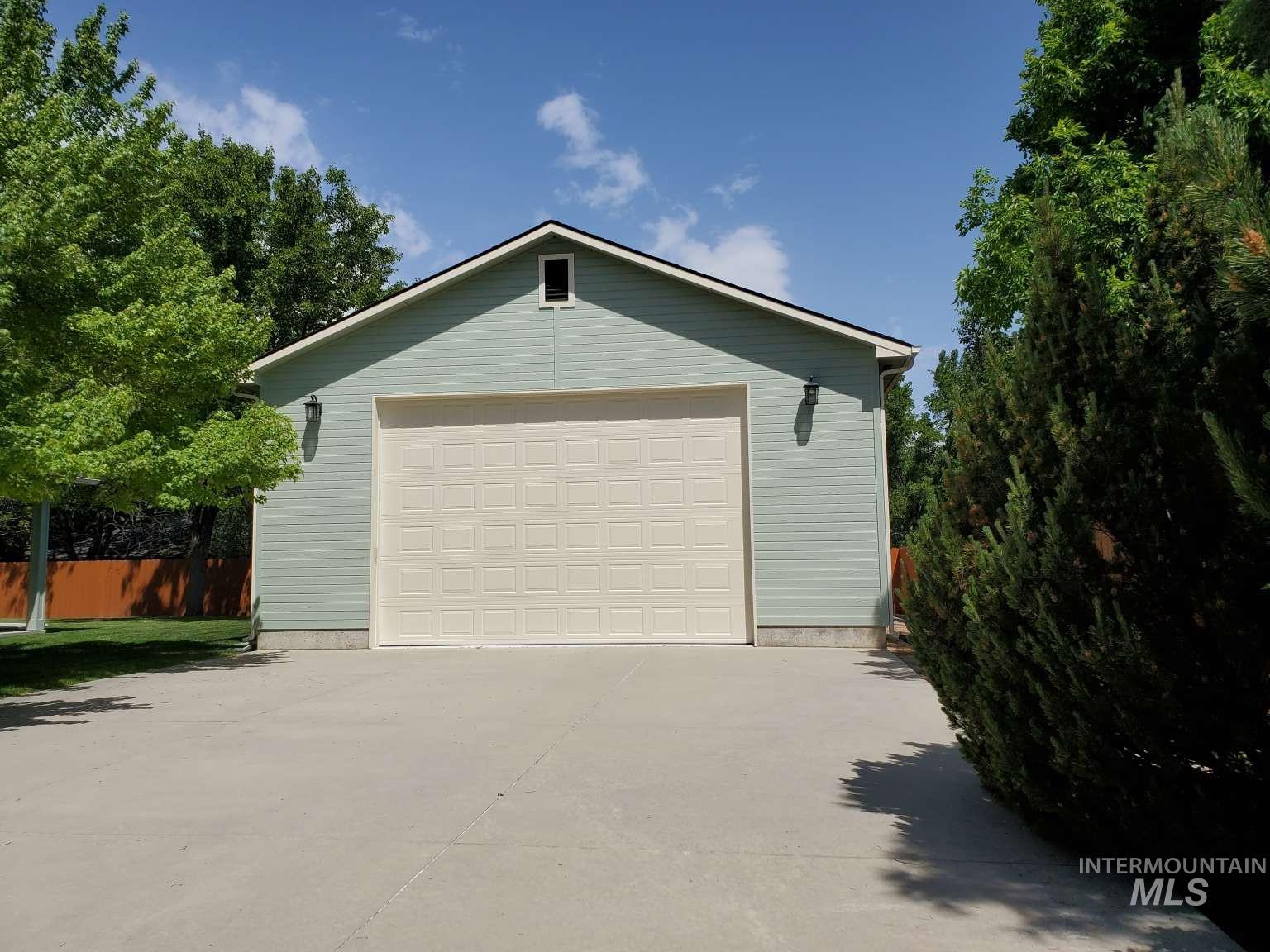 1100 East Wright Street Boise, ID 83706 - Photo 21 of 25 Two-car garage with a light beige paneled door and light blue horizontal siding