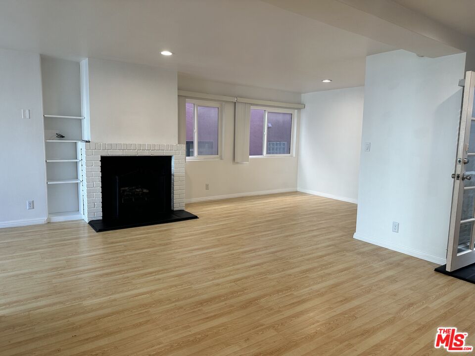 24 Lighthouse Street, Unit A Marina del Rey, CA 90292 - Photo 11 of 39 an empty room with wooden floor and fireplace