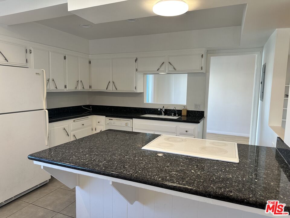 24 Lighthouse Street, Unit A Marina del Rey, CA 90292 - Photo 20 of 39 a kitchen with granite countertop a sink a stove and a refrigerator