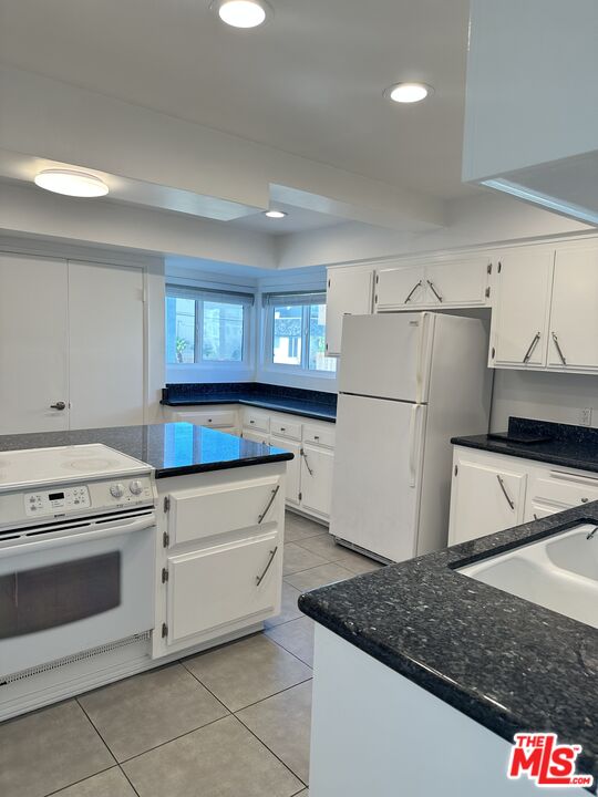24 Lighthouse Street, Unit A Marina del Rey, CA 90292 - Photo 22 of 39 a kitchen with granite countertop a refrigerator sink stove and cabinets