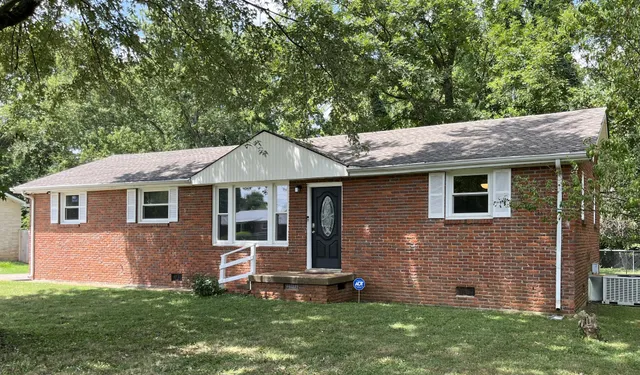 a front view of a house with a garden and yard