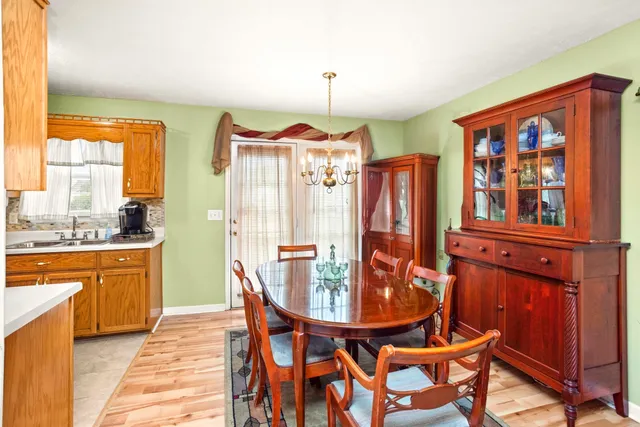 a dining room with furniture a chandelier and wooden floor