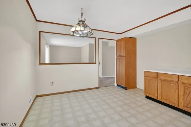 an empty room with chandelier fan