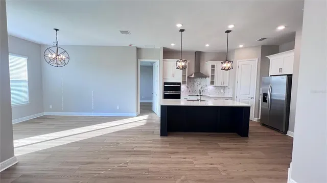 a view of kitchen with refrigerator and window