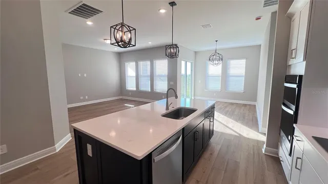a view of a kitchen area with furniture and wooden floor