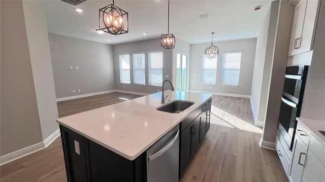 a kitchen with a sink a counter space and stainless steel appliances
