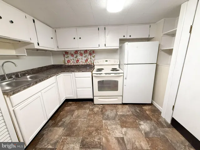 a kitchen with cabinets appliances and a sink