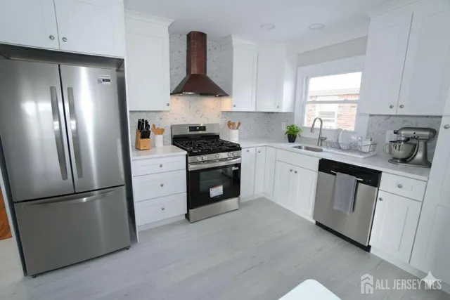 a kitchen with white cabinets and stainless steel appliances
