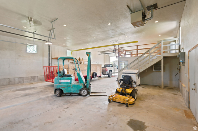 580 North 300 East Logan, UT 84321 - Photo 63 of 74 Spacious interior featuring a concrete floor, high ceilings with recessed lighting, and an overhead garage door