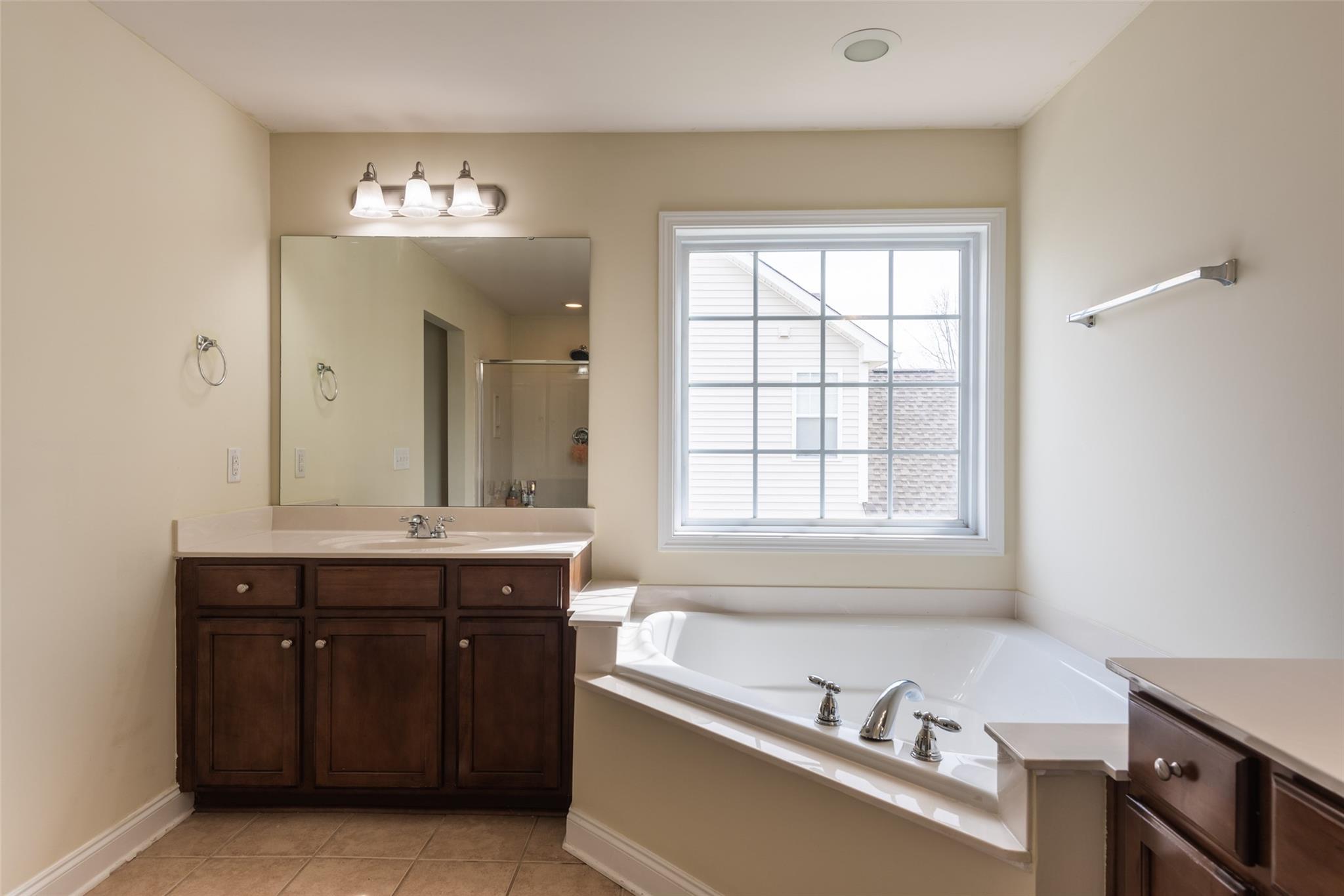 2012 Apogee Drive Indian Trail, NC 28079 - Photo 19 of 28 a bathroom with a tub sink and mirror