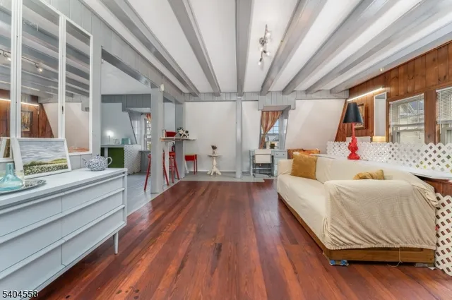 a spacious bedroom with two beds and wooden floor