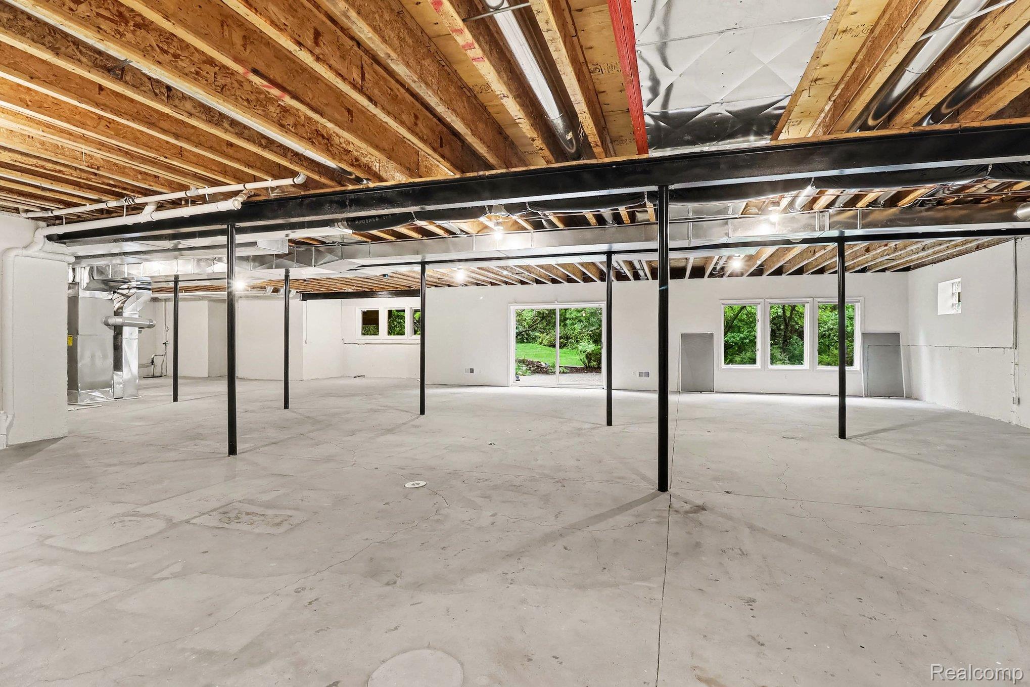 4875 Green Meadow Lane Rochester, MI 48306 - Photo 45 of 60 Unfinished open-concept lower level with exposed wood joists and structural beams