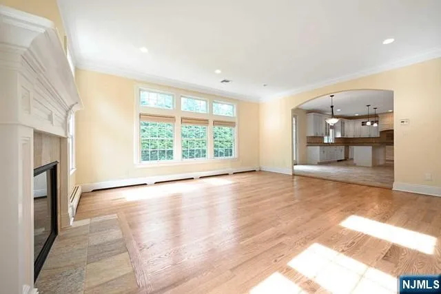 a view of empty room with wooden floor and fireplace