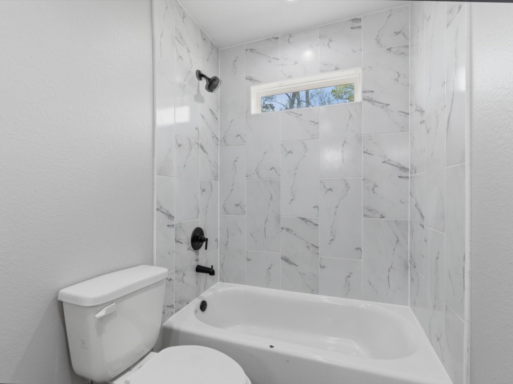 413 South 12th Street Conroe, TX 77301 - Photo 12 of 22 a bathroom with a toilet and a bathtub
