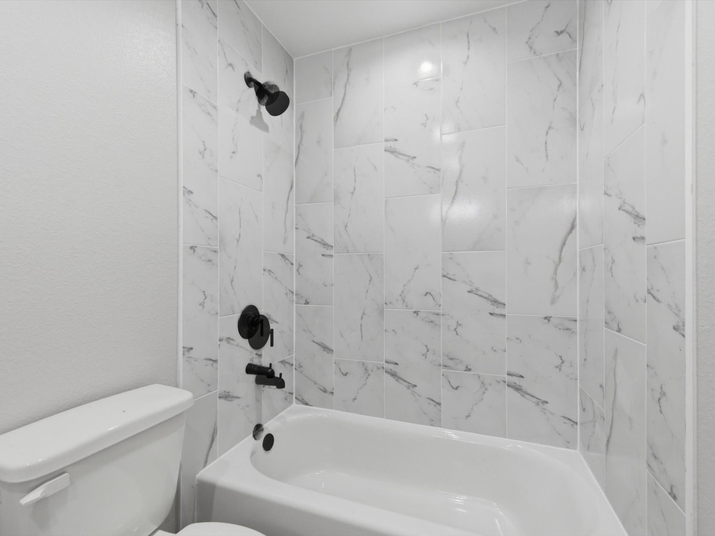 413 South 12th Street Conroe, TX 77301 - Photo 14 of 22 a bathroom with a bathtub and a toilet