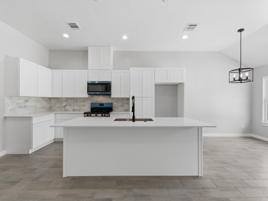 413 South 12th Street Conroe, TX 77301 - Photo 6 of 22 a kitchen with stainless steel appliances a stove top oven a sink a refrigerator and white cabinets