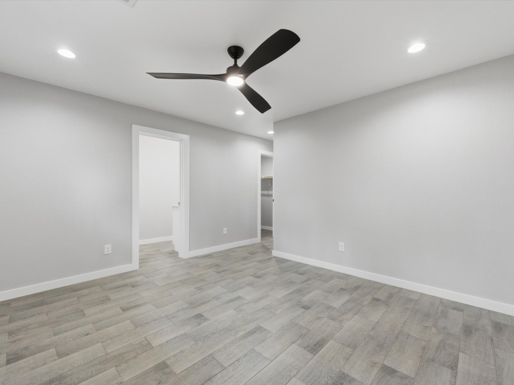 413 South 12th Street Conroe, TX 77301 - Photo 9 of 22 an empty room with ceiling fan and wooden floor