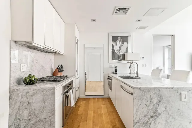 a large kitchen with granite countertop a sink and cabinets