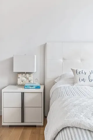 a bedroom with a large white bed and a large window