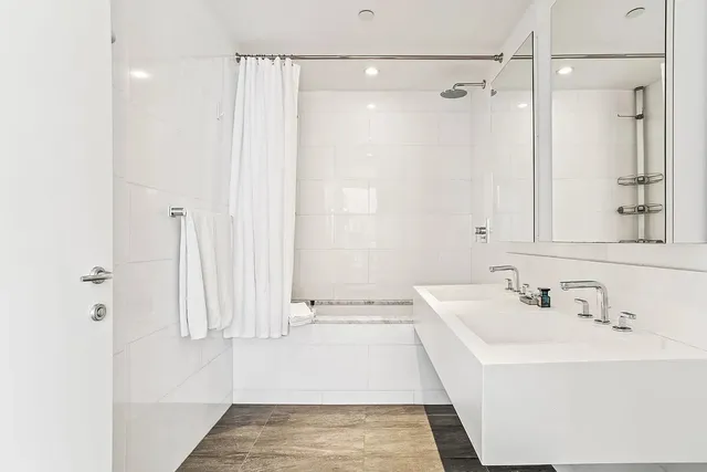 a bedroom with a bed and a lamp on dresser