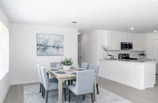 a kitchen with stainless steel appliances kitchen island granite countertop a dining table and chairs