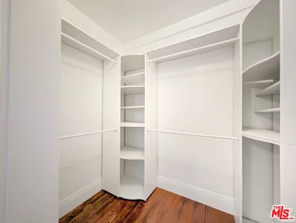a view of walk in closet with empty racks