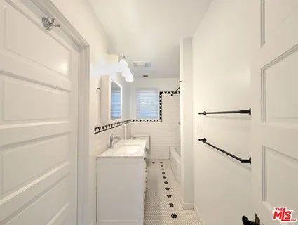 a bathroom with a shower sink and mirror
