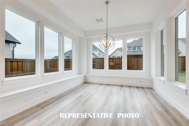 a large white kitchen with kitchen island a large counter space a sink stainless steel appliances and cabinets