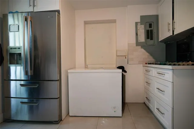 a kitchen with appliances a refrigerator and cabinets