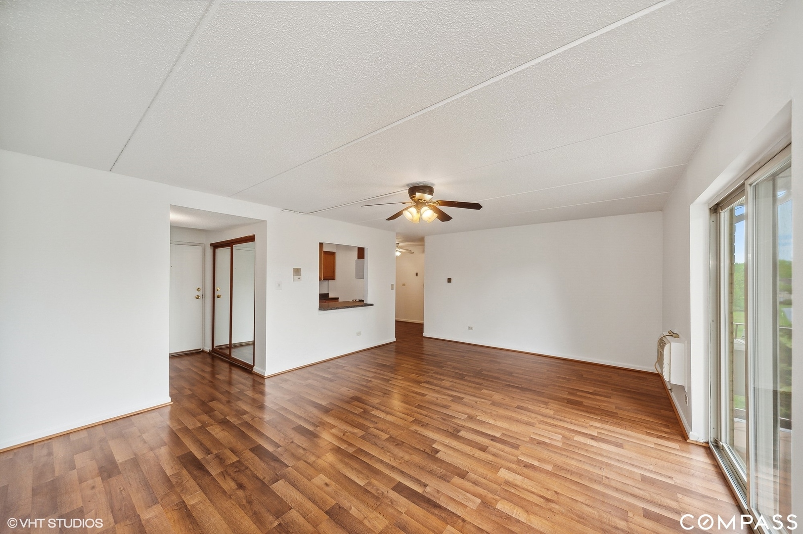 575 Fairway View Drive, Unit 2F Wheeling, IL 60090 - Photo 3 of 14 a view of a livingroom with wooden floor and a ceiling fan
