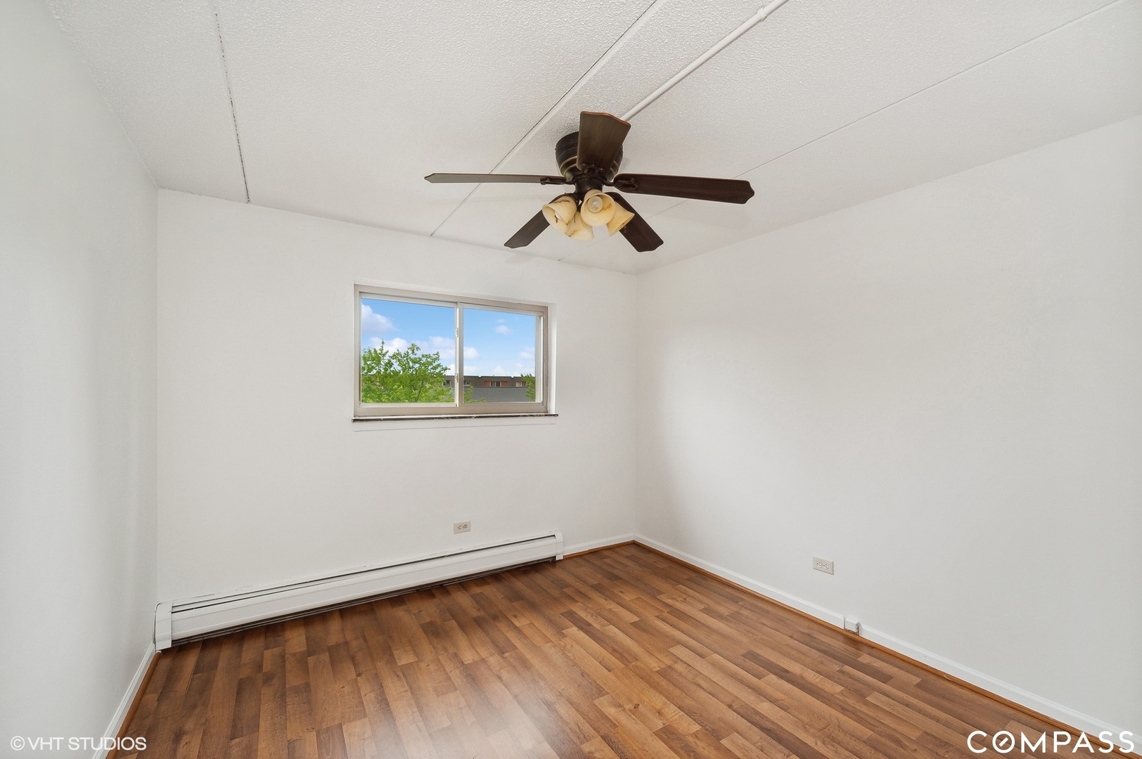 575 Fairway View Drive, Unit 2F Wheeling, IL 60090 - Photo 9 of 14 a view of a room with wooden floor ceiling fan and window