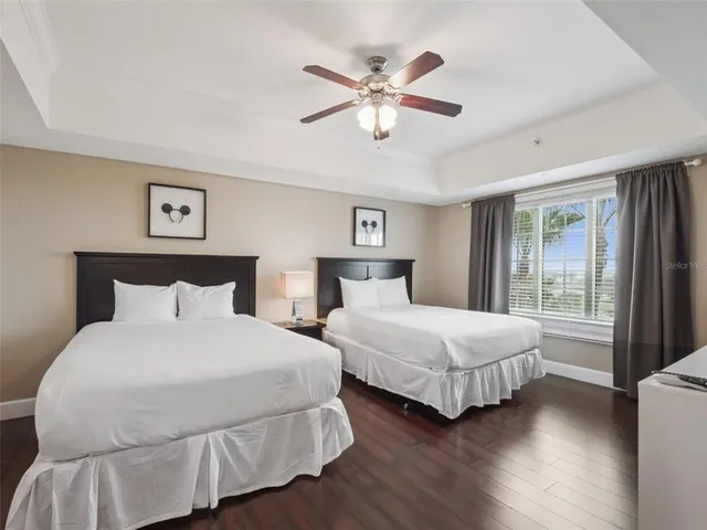a bedroom with two large bed and a chandelier