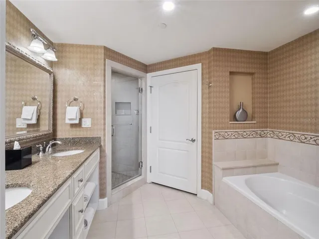a bathroom with a granite countertop tub sink and mirror