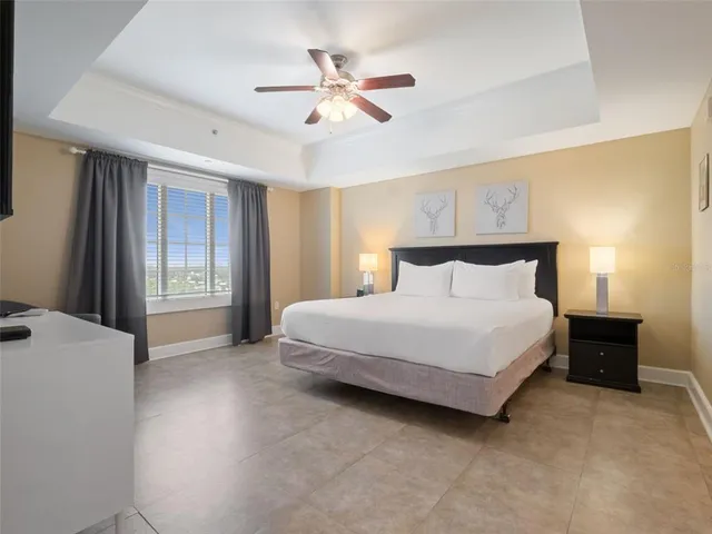 a bedroom with a large bed and a ceiling fan
