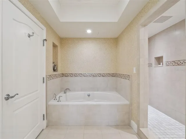 a white bath tub sitting next to a shower