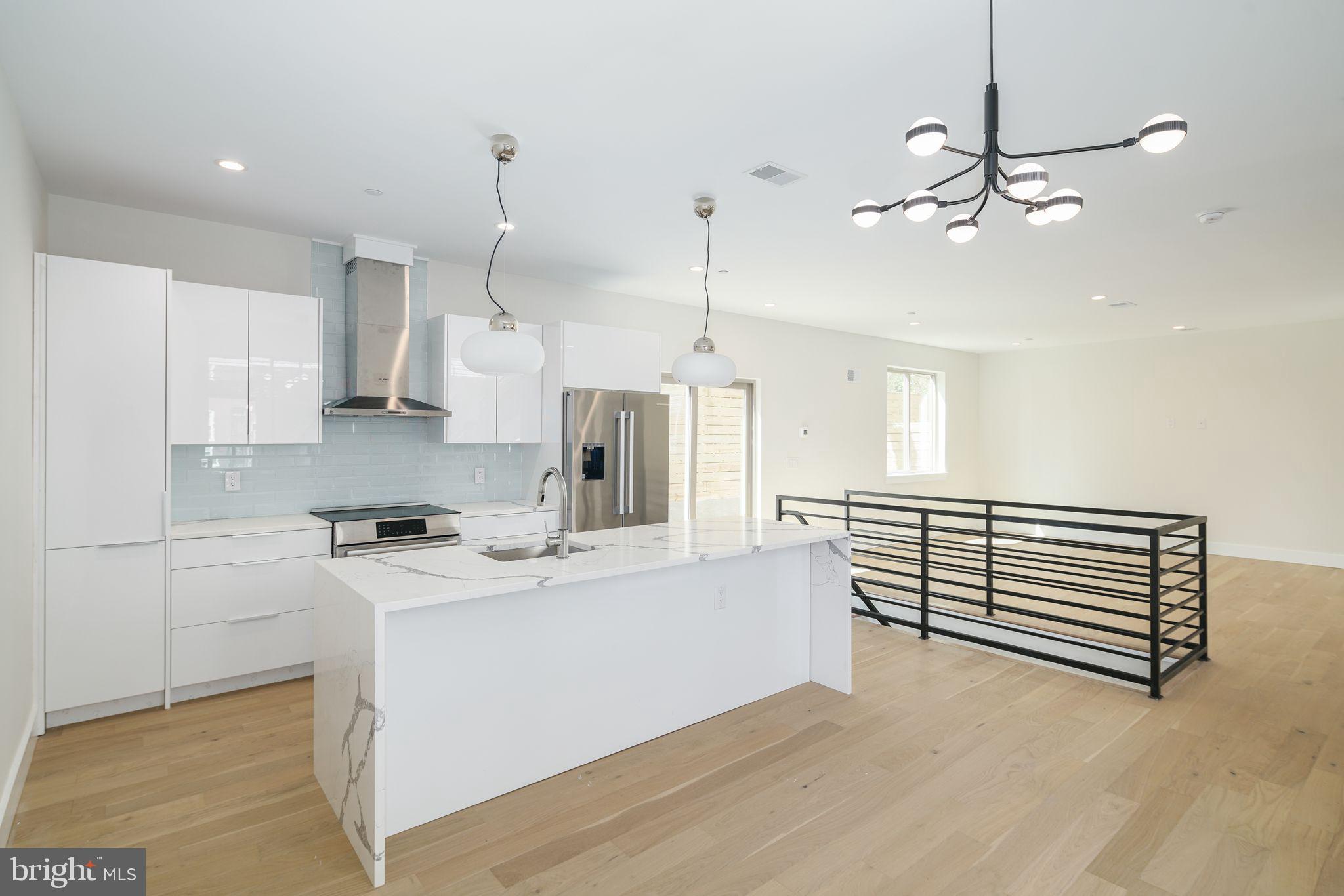 a kitchen with kitchen island a sink stainless steel appliances and white cabinets