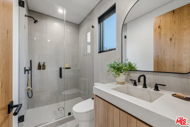 a spacious bedroom with a bed a mirror and table